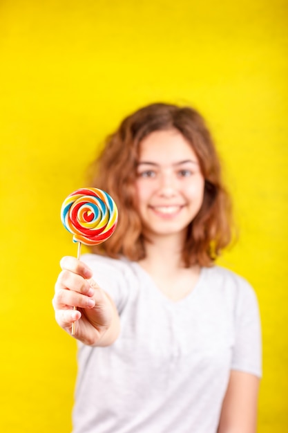 Jovencita sostiene una paleta redonda multicolor en su mano