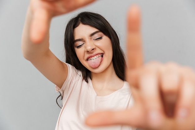 Jovencita toma una foto de ti gesticulando con las manos