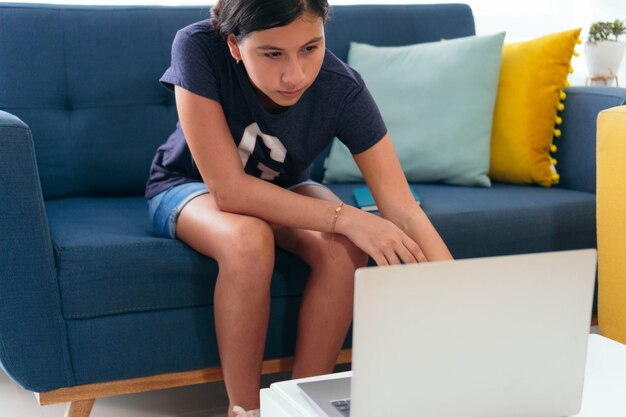 Jovencita trabajando en un portátil en la sala de estar