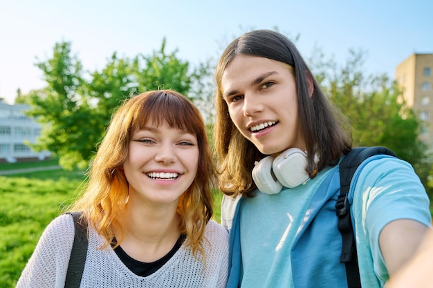 Jóvenes adolescentes amigos chico y chica divirtiéndose riendo tomando foto selfie