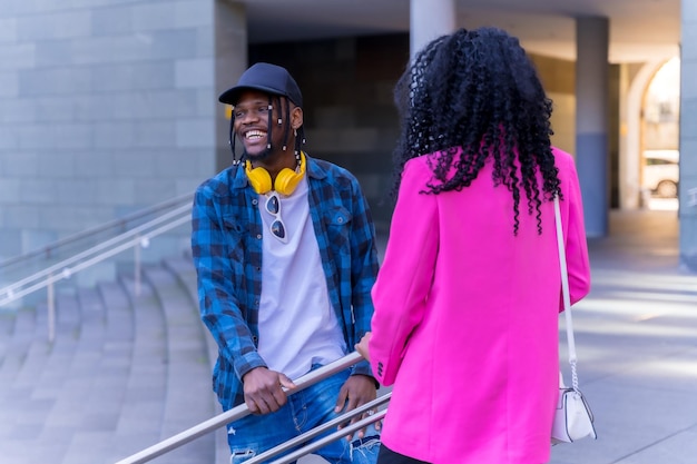 Jóvenes afroamericanas hablando en la ciudad en unas escaleras divirtiéndose