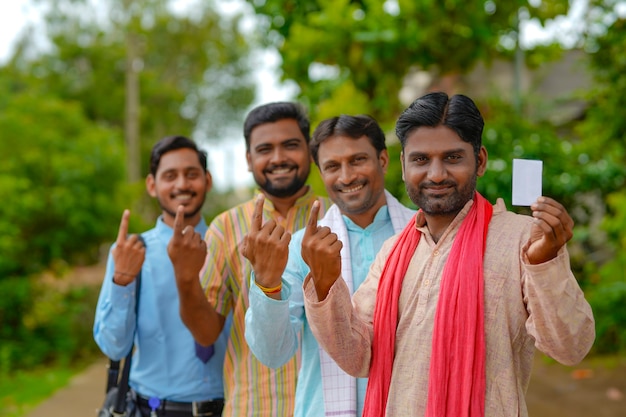 Jóvenes agricultores indios mostrando el dedo después de votar con los oficiales.