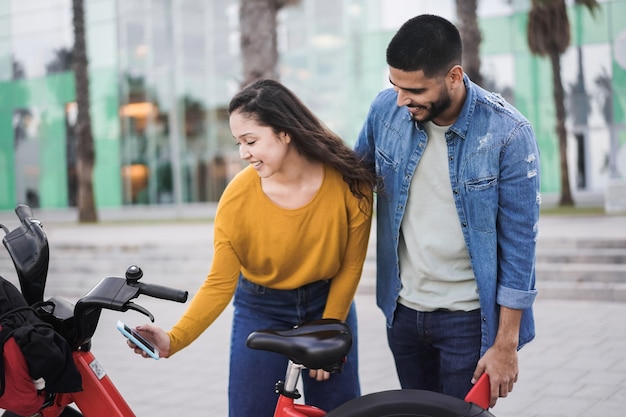 Jóvenes alquilan bicicleta eléctrica con aplicación para smartphone