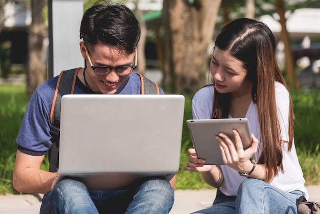 Jóvenes y amigas compañeros de clase sentados consultan juntos en una laptop en la universidad