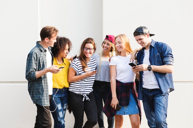 Jóvenes amigos adultos usando smartphones juntos al aire libre concepto de cultura juvenil