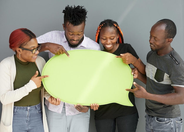 Jóvenes amigos afroamericanos sosteniendo burbujas de pensamiento de carteles de copyspace