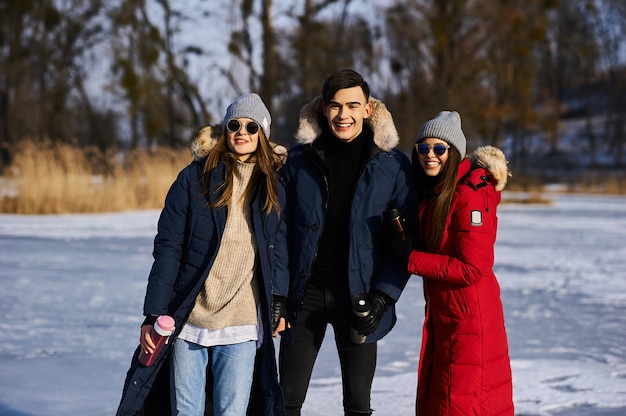 Jóvenes amigos divirtiéndose al aire libre en invierno
