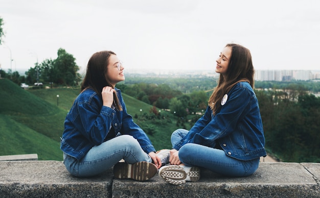 Jóvenes amigos hablando y divirtiéndose en el parque de la ciudad