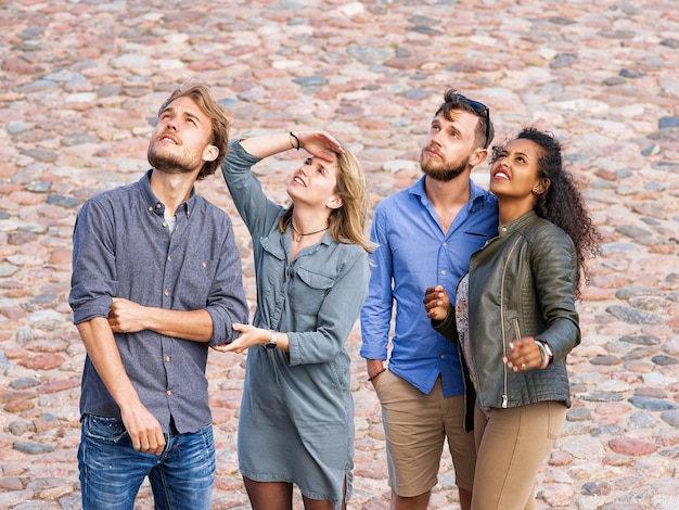 Foto jóvenes amigos mirando hacia arriba con concepto de interés