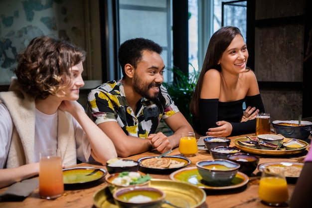 Foto jóvenes amigos multiétnicos celebrando algo en un café