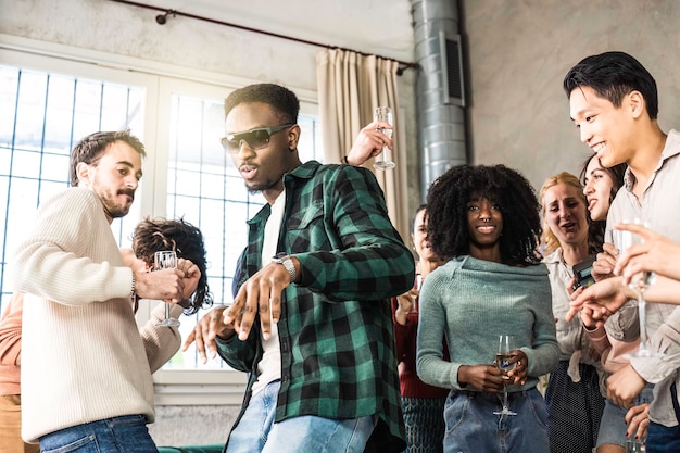 Jóvenes amigos multiétnicos que tienen una fiesta en casa juntos Gente divertida y diversa que se divierte bailando y cantando en la sala de estar durante una fiesta genial Concepto de estilo de vida juvenil Filtro brillante