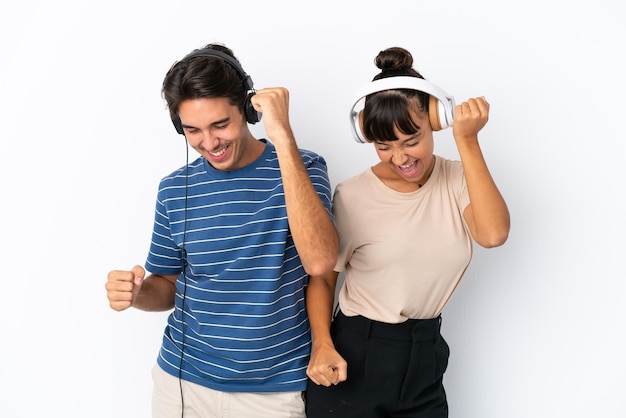 Jóvenes amigos de raza mixta aislados de fondo blanco escuchando música y bailando