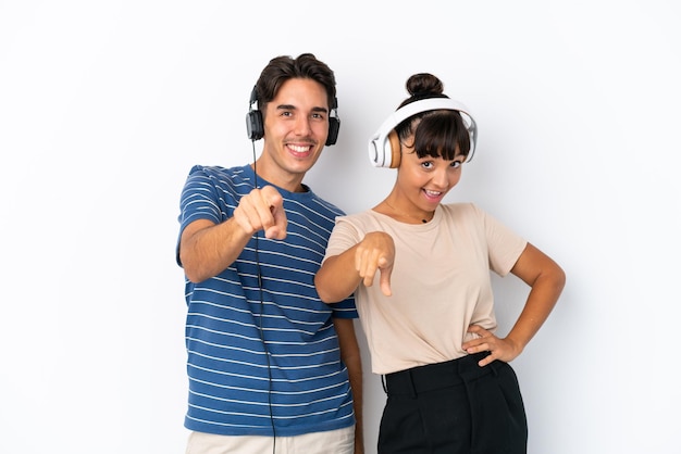 Jóvenes amigos de raza mixta aislados sobre fondo blanco escuchando música