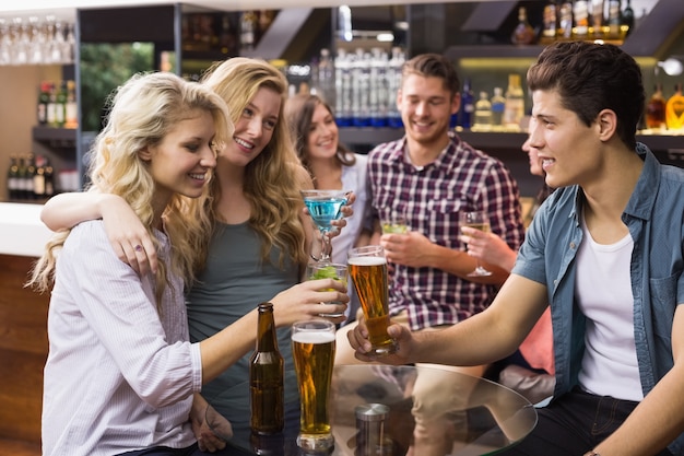 Jóvenes amigos tomando una copa juntos