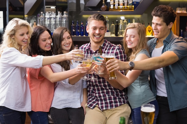 Jóvenes amigos tomando una copa juntos