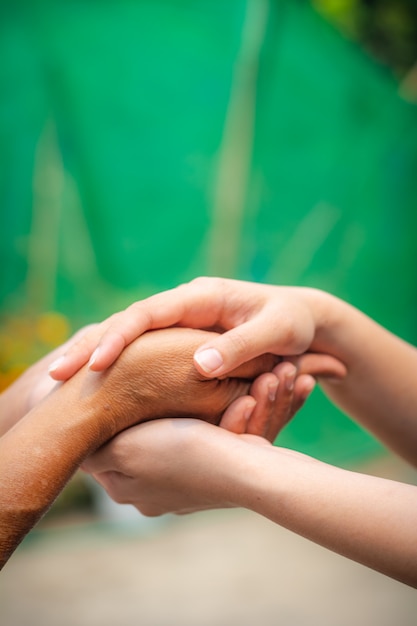 Foto jóvenes asiáticos y asiáticos jóvenes tomados de la mano.