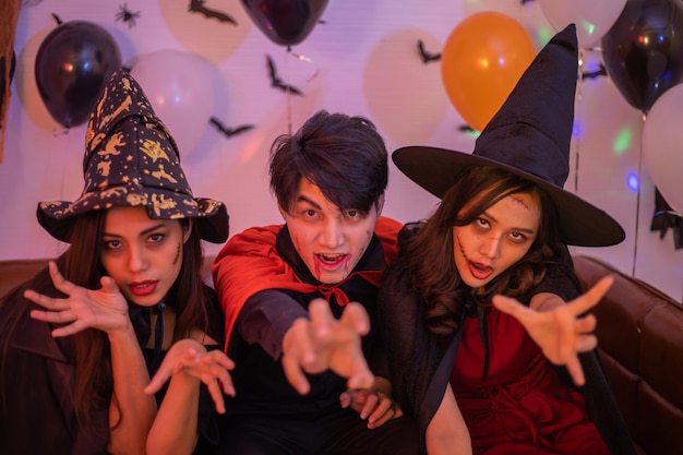 Foto jóvenes asiáticos en disfraces celebrando halloween grupo de amigos divirtiéndose en la fiesta en la discoteca
