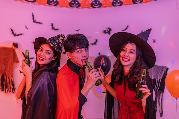 Jóvenes asiáticos en disfraces celebrando halloween Grupo de amigos divirtiéndose en la fiesta en la discoteca