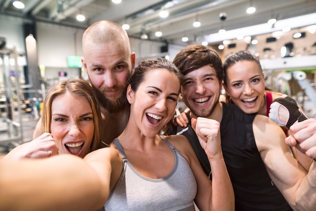 Foto jóvenes atletas divirtiéndose en el gimnasio, tomando selfies