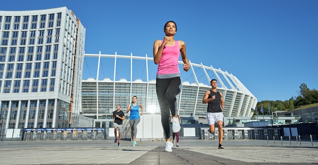 Jóvenes atletas que compiten en correr en el fondo del estadio