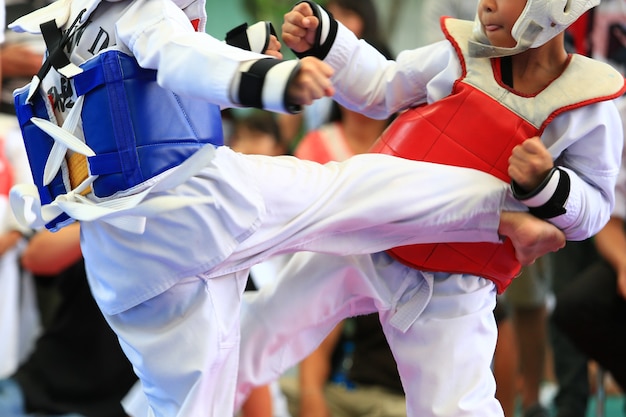 Jóvenes atletas de Taekwondo están peleando durante la competencia