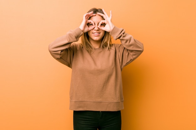 Jóvenes auténticos carismáticos personas reales mujer contra una pared que muestra bien firmar sobre los ojos