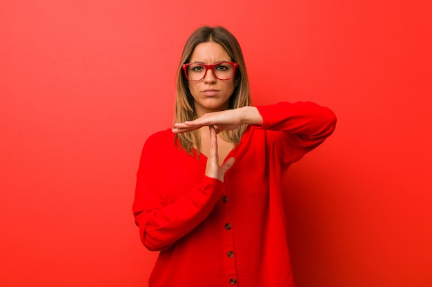 Jóvenes auténticos carismáticos personas reales mujer contra una pared que muestra un gesto de tiempo de espera.