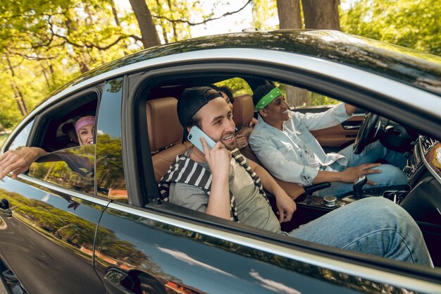 Jóvenes en el auto luciendo felices y contentos