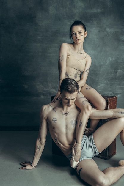 Los jóvenes bailarines de ballet moderno posando sobre fondo gris de estudio