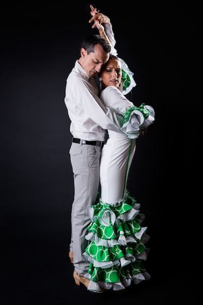 Foto jóvenes bailarines de flamenco en hermoso vestido sobre fondo negro.