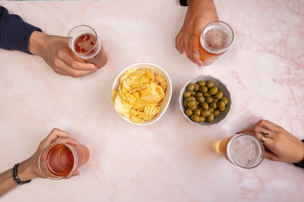 Jóvenes bebiendo cervezas y pasando un buen rato en una mesa