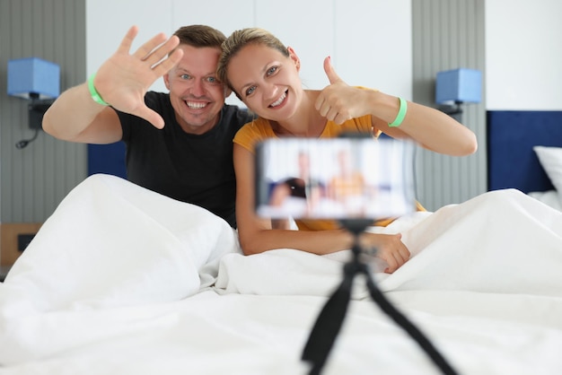 Jóvenes blogueros transmiten en vivo desde la comunicación de la habitación del hotel en el concepto de redes sociales