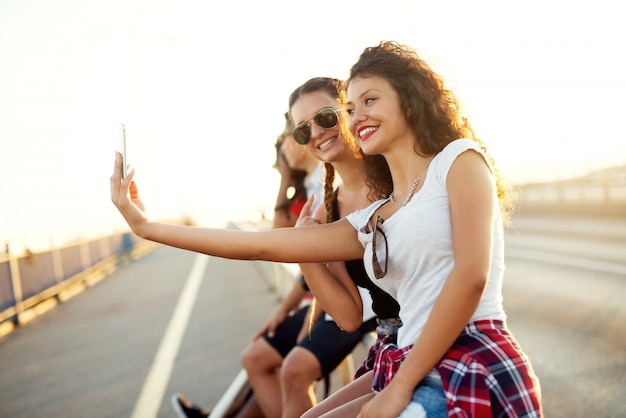 Foto jóvenes chicas guapas tomando una selfie en la calle.