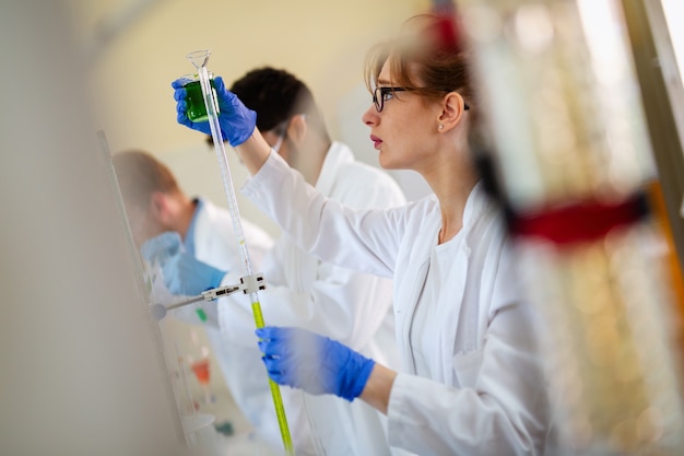 Jóvenes científicos, estudiantes de química que trabajan en laboratorio