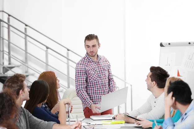 Jóvenes colegas trabajando y discutiendo en la reunión de negocios en la oficina.