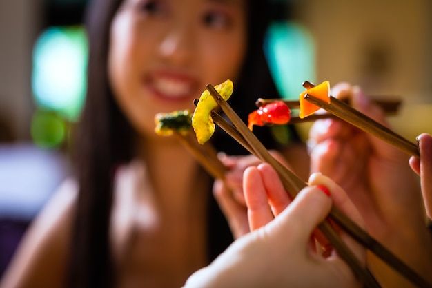 Jóvenes comiendo en el restaurante de Asia.