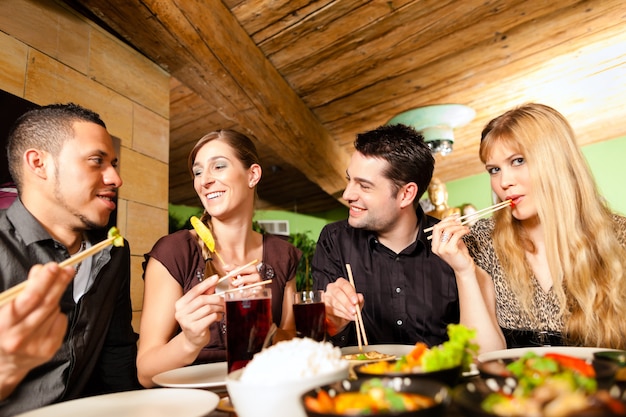 Jóvenes comiendo en restaurante tailandés