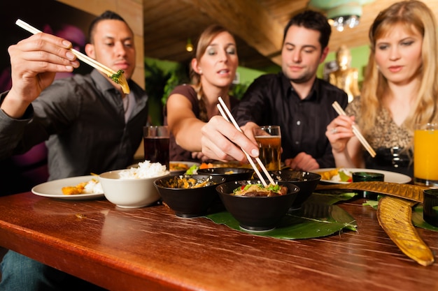 Jóvenes comiendo en restaurante tailandés