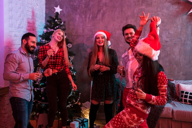 Jóvenes con copas de champán en la fiesta de Navidad