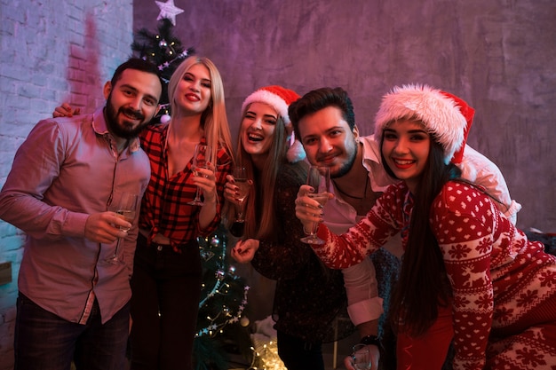 Jóvenes con copas de champán en la fiesta de Navidad