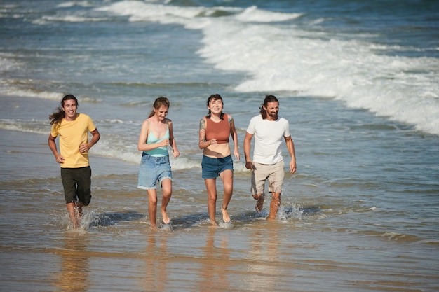 Jóvenes corriendo en la playa