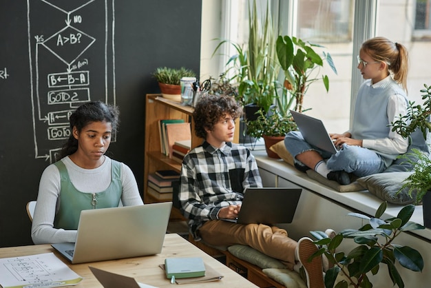 Jóvenes desarrolladores que usan computadoras en clase