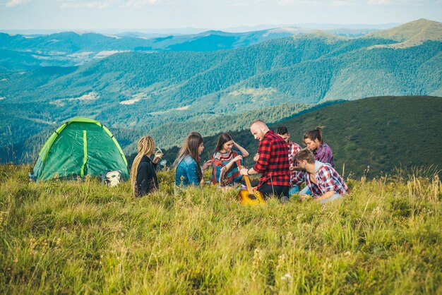 Los jóvenes descansan en el campo, un grupo de amigos en el campo, caminan, los jóvenes hacen senderismo en el campo.