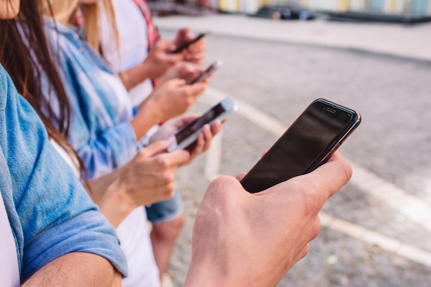 Foto jóvenes con diferentes teléfonos en las manos