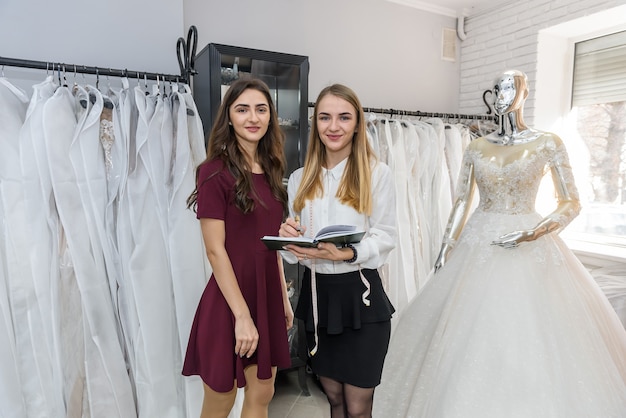 Jóvenes diseñadores que trabajan en el vestido de novia en el salón