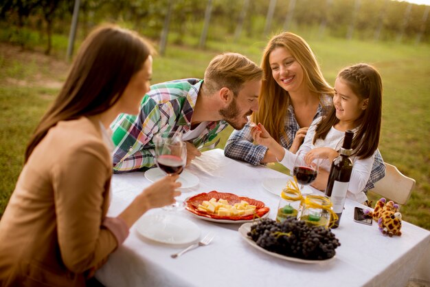 Los jóvenes disfrutan de una cena y cata de vinos en el viñedo.