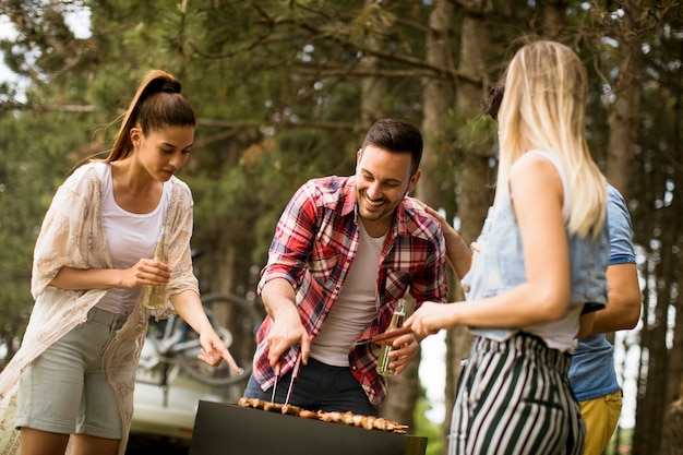 Jóvenes disfrutando de la fiesta de la barbacoa en la naturaleza.