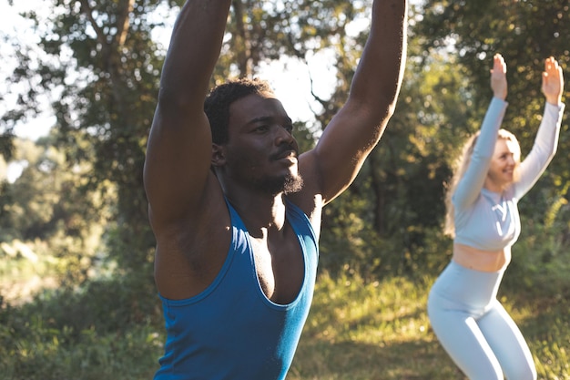 Los jóvenes diversos practican yoga en la naturaleza.