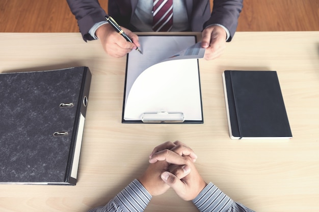 Jóvenes ejecutivos atractivos hombre leyendo su currículum, historial de trabajo del solicitante en un clipboa