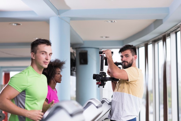 jóvenes ejerciendo un cardio en cinta rodante corriendo lomo en un gimnasio moderno